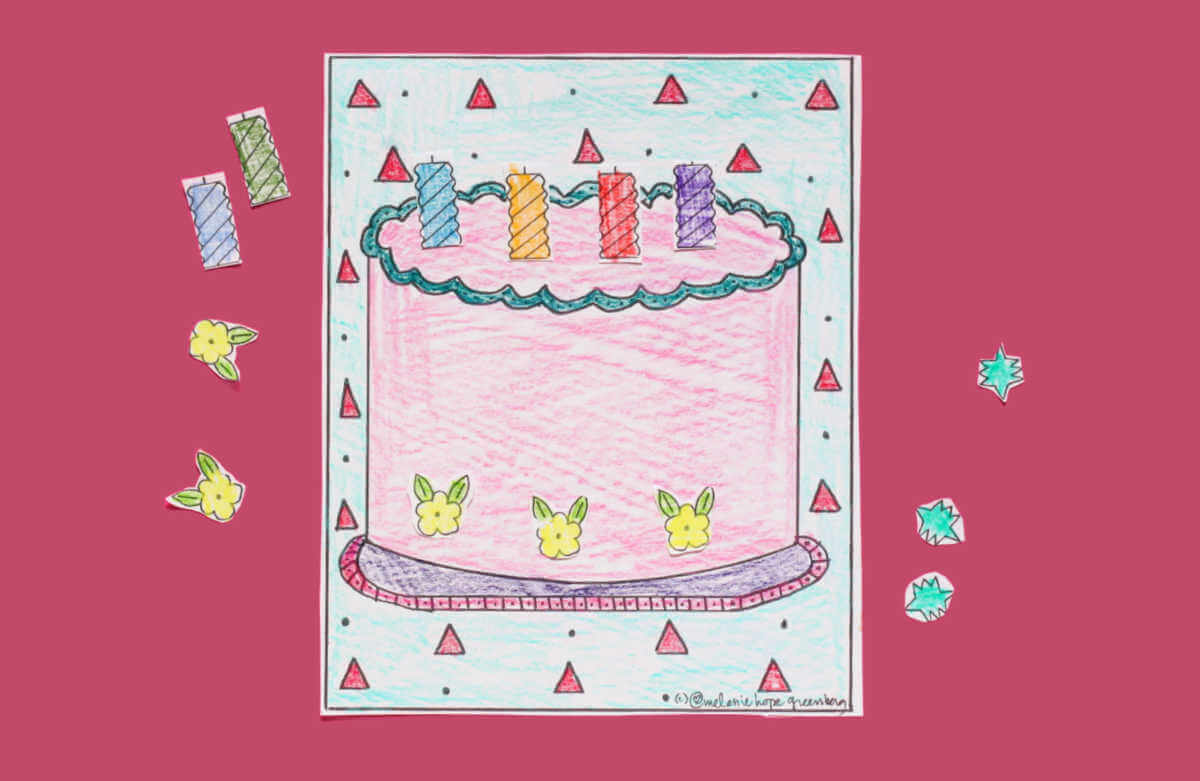 Colored in birthday cake coloring page with cut out candles and decorations.