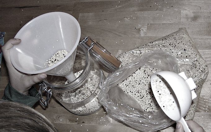 Filling a jar using a measuring cup and funnel