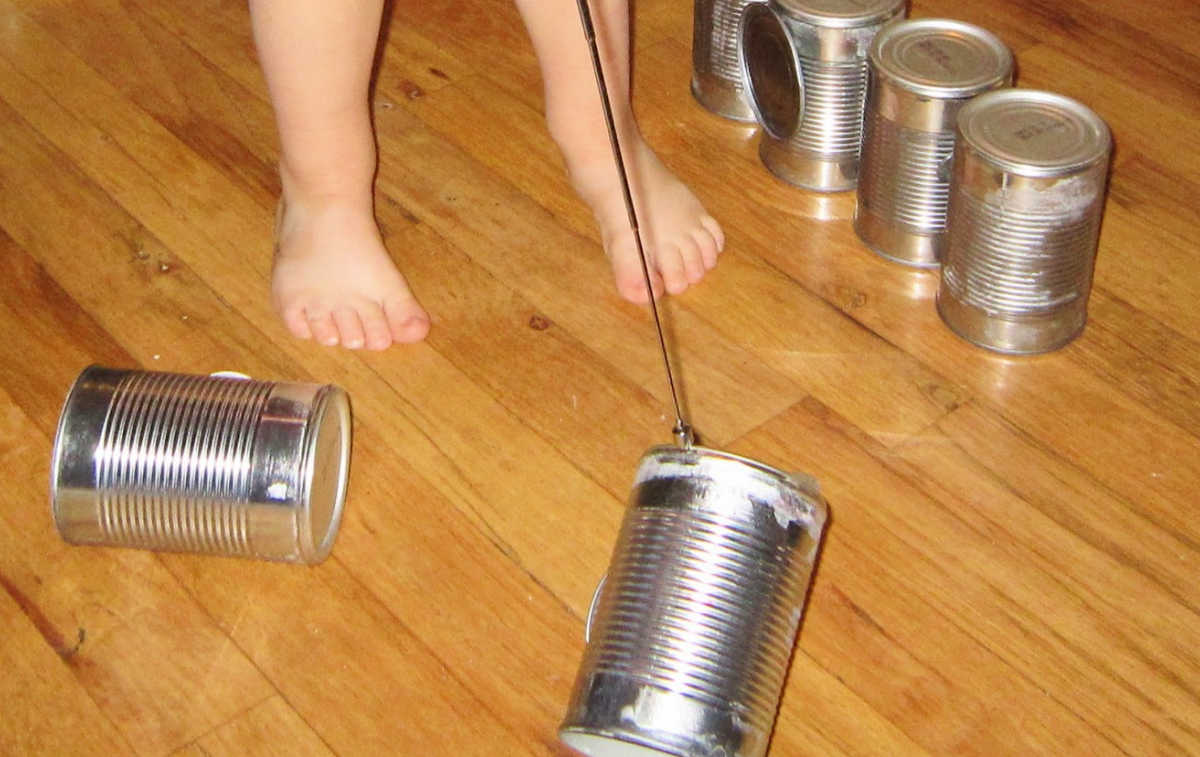 Child picking up magnet building set parts with telescoping pick up tool