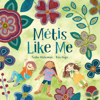 Métis Like Me picture book cover with illustration of children lying on the grass surrounded by flowers.