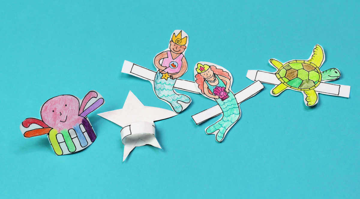 Paper ocean finger puppets including a rainbow colored octopus, face down starfish, two mermaids and a turtle.