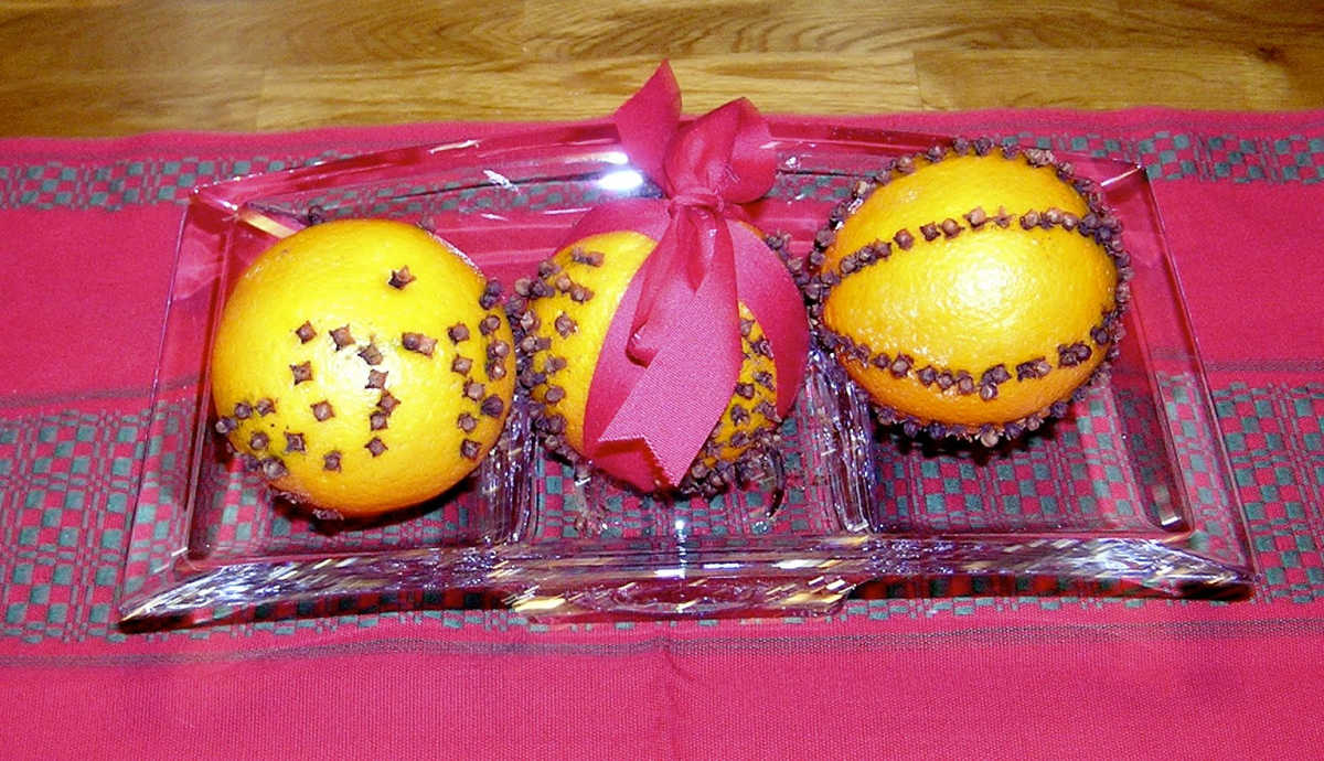 Three orange and clove pomanders in a glass dish. 