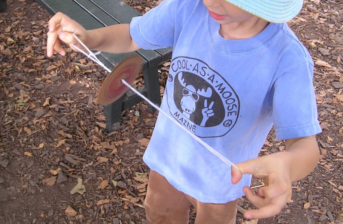 Child spinning a homemade whirligig